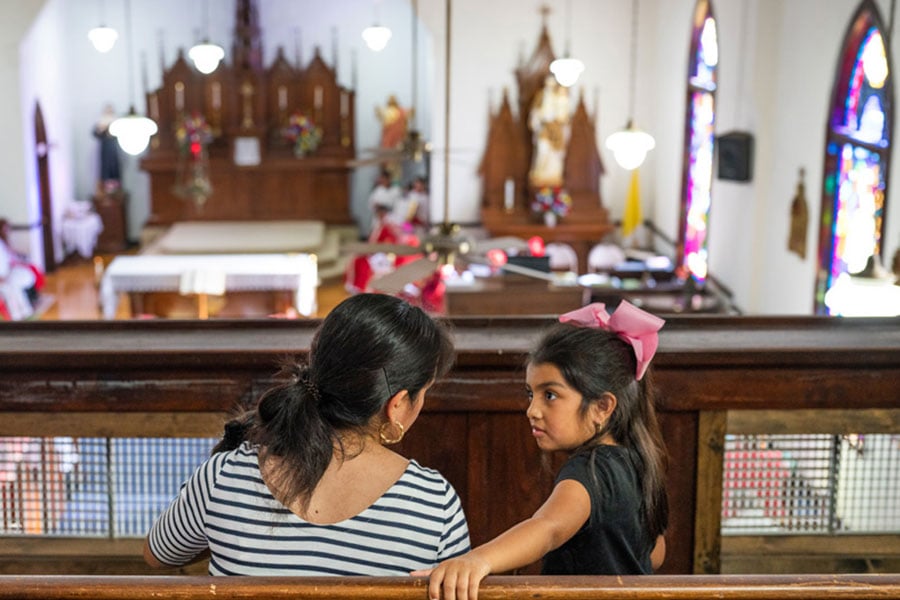 A mother and daughter stand before a sanctuary